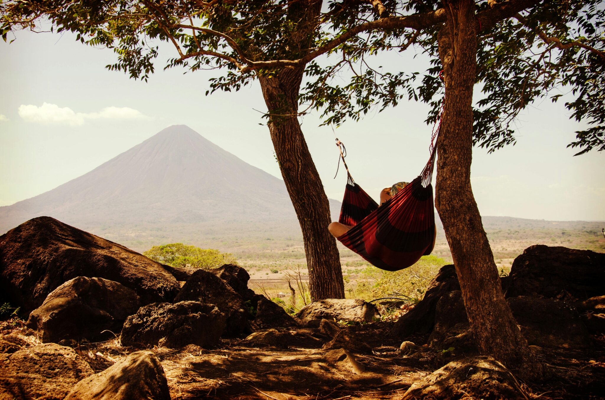 A person relaxing in a hammock in front of a mountain